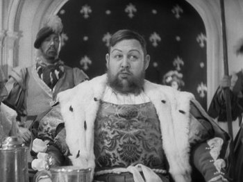 Movie still from “The Private Life of Henry VIII” (1933), directed by Alexander Korda – A man sitting in a chair with a beard; Close Up shot, Low angle