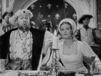 Movie still from “The Private Life of Henry VIII” (1933), directed by Alexander Korda – A man and a woman sitting at a dinner table; Medium shot, Low angle