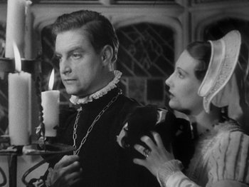 Movie still from “The Private Life of Henry VIII” (1933), directed by Alexander Korda – A man and a woman standing next to each other in front of a candle; Medium shot, Low angle