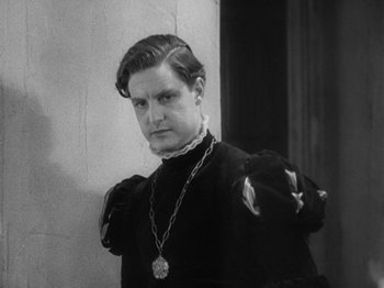 Movie still from “The Private Life of Henry VIII” (1933), directed by Alexander Korda – A black and white photo of a man wearing a necklace; Medium shot, High angle