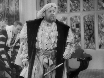 Movie still from “The Private Life of Henry VIII” (1933), directed by Alexander Korda – A black and white photo of a man dressed as a king holding a sword; Medium shot, Over the shoulder angle