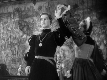 Movie still from “The Private Life of Henry VIII” (1933), directed by Alexander Korda – A man and a woman dressed in medieval garb dancing; Medium shot, Low angle