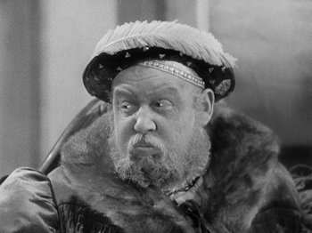 Movie still from “The Private Life of Henry VIII” (1933), directed by Alexander Korda – An old man with a beard wearing a hat; Close Up shot, Over the shoulder angle