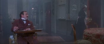 Movie still from “The Private Life of Sherlock Holmes” (1970), directed by Billy Wilder – A person sitting at a table in a room; Wide shot, High angle