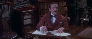 Movie still from “The Private Life of Sherlock Holmes” (1970), directed by Billy Wilder – A man sitting at a desk in front of papers; Medium shot, High angle