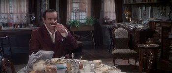 Movie still from “The Private Life of Sherlock Holmes” (1970), directed by Billy Wilder – A man sitting at a dinner table eating a piece of cake; Medium shot, Over the shoulder angle
