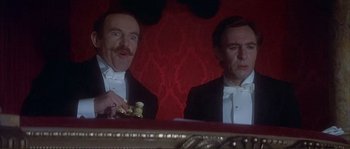 Movie still from “The Private Life of Sherlock Holmes” (1970), directed by Billy Wilder – Two men in tuxedos sitting in front of a table; Medium shot, Low angle