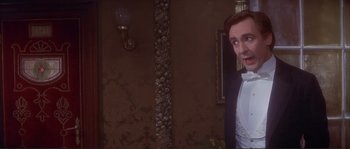 Movie still from “The Private Life of Sherlock Holmes” (1970), directed by Billy Wilder – A man in a tuxedo standing in front of a mirror; Medium shot, Over the shoulder angle