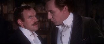Movie still from “The Private Life of Sherlock Holmes” (1970), directed by Billy Wilder – Two men in tuxedos looking at each other; Close Up shot, Low angle