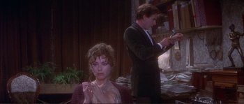 Movie still from “The Private Life of Sherlock Holmes” (1970), directed by Billy Wilder – A man and a woman are standing in front of a stack of papers; Medium shot, High angle