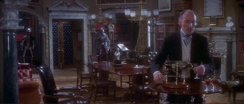 Movie still from “The Private Life of Sherlock Holmes” (1970), directed by Billy Wilder – A room filled with tables and chairs and a man standing in front of a table; Wide shot, High angle