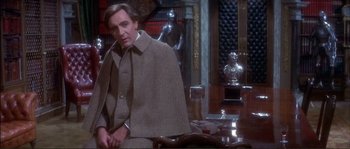Movie still from “The Private Life of Sherlock Holmes” (1970), directed by Billy Wilder – A man sitting in front of a table in a room; Medium shot, High angle