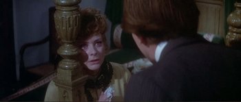 Movie still from “The Private Life of Sherlock Holmes” (1970), directed by Billy Wilder – A woman looking at a man in a suit in front of a mirror; Close Up shot, Over the shoulder angle