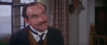 Movie still from “The Private Life of Sherlock Holmes” (1970), directed by Billy Wilder – An older man with a mustache wearing a suit and tie; Close Up shot, Over the shoulder angle