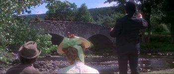 Movie still from “The Private Life of Sherlock Holmes” (1970), directed by Billy Wilder – A woman wearing a green hat and a green bow tie; Extreme Wide shot, Low angle