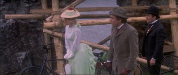 Movie still from “The Private Life of Sherlock Holmes” (1970), directed by Billy Wilder – A man and a woman standing next to each other near a bicycle; Medium shot, Over the shoulder angle