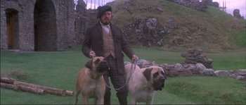 Movie still from “The Private Life of Sherlock Holmes” (1970), directed by Billy Wilder – A man with two dogs chained to a chain; Medium shot, Low angle