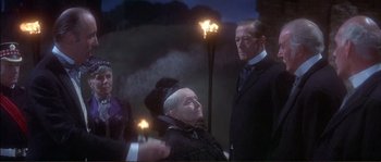 Movie still from “The Private Life of Sherlock Holmes” (1970), directed by Billy Wilder – A man and a woman standing next to each other in front of torches; Medium shot, Over the shoulder angle