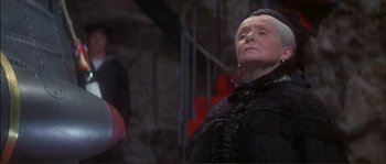 Movie still from “The Private Life of Sherlock Holmes” (1970), directed by Billy Wilder – An older woman in a black dress looking up; Medium shot, Low angle