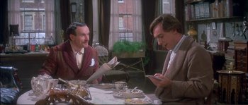 Movie still from “The Private Life of Sherlock Holmes” (1970), directed by Billy Wilder – Two men sitting at a dinner table looking at their cell phones; Medium shot, Over the shoulder angle