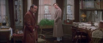 Movie still from “The Private Life of Sherlock Holmes” (1970), directed by Billy Wilder – Two men standing next to each other in front of a window; Medium shot, Low angle