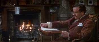 Movie still from “The Private Life of Sherlock Holmes” (1970), directed by Billy Wilder – A person sitting in front of a fireplace; Medium shot, High angle