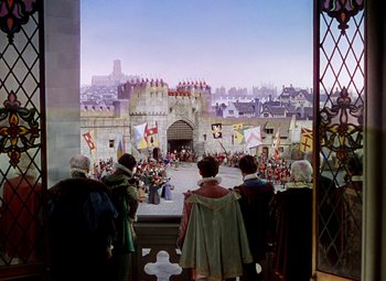 Movie still from “The Private Lives of Elizabeth and Essex” (1939), directed by Michael Curtiz – A group of people standing in front of a castle; Extreme Wide shot, High angle