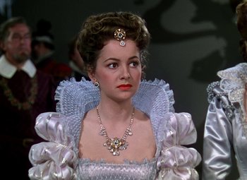 Movie still from “The Private Lives of Elizabeth and Essex” (1939), directed by Michael Curtiz – A woman in a white dress and a necklace; Close Up shot, Over the shoulder angle