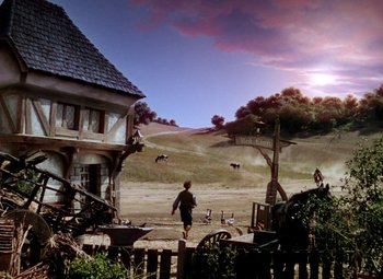 Movie still from “The Private Lives of Elizabeth and Essex” (1939), directed by Michael Curtiz – A person walking in front of an old house; Extreme Wide shot, Low angle