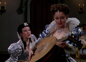 Movie still from “The Private Lives of Elizabeth and Essex” (1939), directed by Michael Curtiz – Two women dressed up in renaissance costumes playing a musical instrument; Medium shot, Low angle