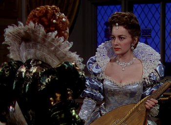 Movie still from “The Private Lives of Elizabeth and Essex” (1939), directed by Michael Curtiz – A woman dressed in renaissance clothing looking at another woman; Medium shot, Over the shoulder angle