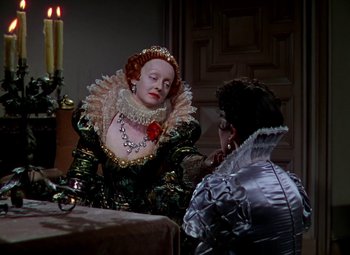 Movie still from “The Private Lives of Elizabeth and Essex” (1939), directed by Michael Curtiz – A woman dressed as an elizabethan woman and a man dressed as an elizabethan man; Medium shot, Over the shoulder angle