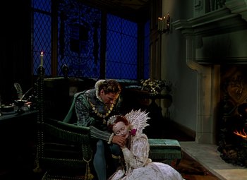 Movie still from “The Private Lives of Elizabeth and Essex” (1939), directed by Michael Curtiz – A man and a woman sitting on a couch; Wide shot, High angle