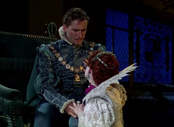 Movie still from “The Private Lives of Elizabeth and Essex” (1939), directed by Michael Curtiz – A man and a woman dressed in medieval garb holding hands; Medium shot, Over the shoulder angle