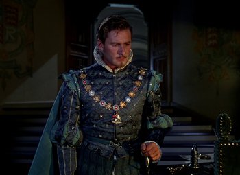 Movie still from “The Private Lives of Elizabeth and Essex” (1939), directed by Michael Curtiz – A man dressed in medieval clothing holding a sword; Medium shot, Over the shoulder angle