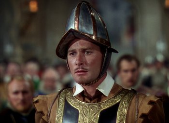 Movie still from “The Private Lives of Elizabeth and Essex” (1939), directed by Michael Curtiz – A person wearing a helmet; Close Up shot, Over the shoulder angle