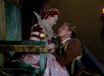 Movie still from “The Private Lives of Elizabeth and Essex” (1939), directed by Michael Curtiz – A man and a woman sitting on a chair; Medium shot, High angle