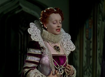 Movie still from “The Private Lives of Elizabeth and Essex” (1939), directed by Michael Curtiz – A woman dressed as a renaissance princess in a costume; Medium shot, Low angle