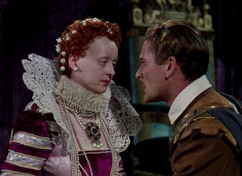 Movie still from “The Private Lives of Elizabeth and Essex” (1939), directed by Michael Curtiz – A man and a woman in medieval garb face each other; Close Up shot, Over the shoulder angle