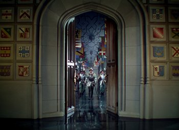 Movie still from “The Private Lives of Elizabeth and Essex” (1939), directed by Michael Curtiz – A group of people riding motorcycles through a doorway; Extreme Wide shot, High angle