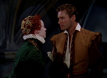 Movie still from “The Private Lives of Elizabeth and Essex” (1939), directed by Michael Curtiz – A man and a woman in medieval garb talking to each other; Medium shot, High angle
