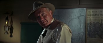 An older man wearing a hat and a tie