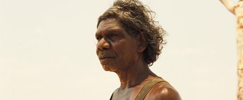 Movie still from “The Proposition” (2005), directed by John Hillcoat – An older man with long curly hair is looking into the distance; Close Up shot, High angle