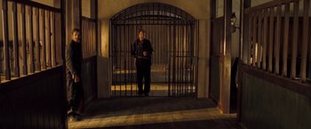 Movie still from “The Proposition” (2005), directed by John Hillcoat – A man standing in front of an iron gate; Wide shot, Low angle