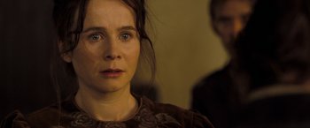 Movie still from “The Proposition” (2005), directed by John Hillcoat – A person wearing a brown dress; Close Up shot, Over the shoulder angle