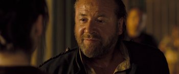 Movie still from “The Proposition” (2005), directed by John Hillcoat – An older man with a beard and a mustache; Close Up shot, Over the shoulder angle