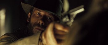Movie still from “The Proposition” (2005), directed by John Hillcoat – A person holding a gun; Close Up shot, Over the shoulder angle