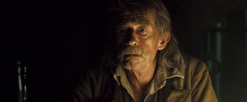 Movie still from “The Proposition” (2005), directed by John Hillcoat – An old man with long hair and a beard; Close Up shot, Over the shoulder angle