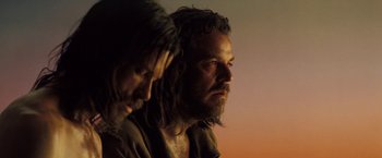 Movie still from “The Proposition” (2005), directed by John Hillcoat – A man with long hair and a beard is looking into the distance; Close Up shot, Low angle