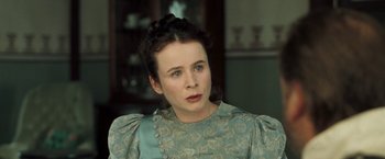 Movie still from “The Proposition” (2005), directed by John Hillcoat – A woman in a green and white dress looking at the camera; Close Up shot, Over the shoulder angle